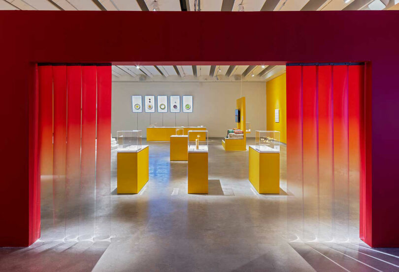 museum space with red framing and yellow pedestals