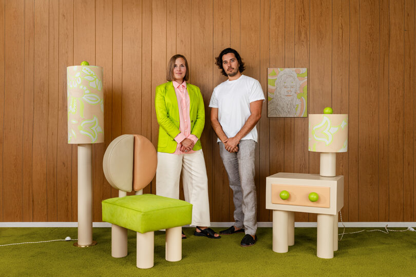 geometric collection of furniture and lighting accented by pink and lime green details with the two designers standing behind them