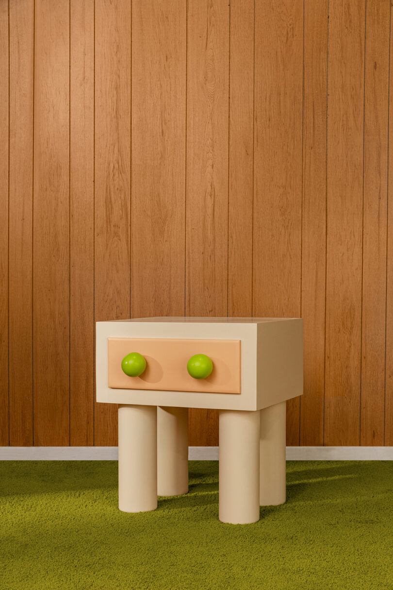 geometric wood nightstand with pink drawer and lime green pulls