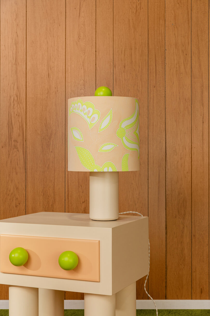 simple lamp base with pastel floral drum shade sitting on nightstand