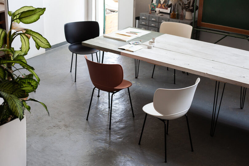 four modern chairs around a long conference table