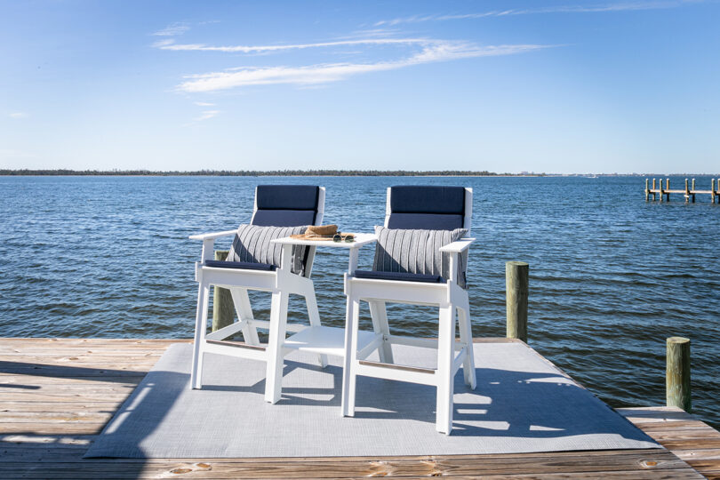 two white hi-rise chairs overlooking the water