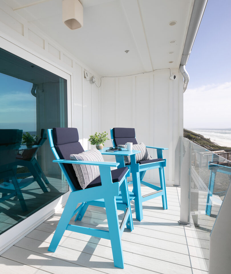 two teal blue high-rise chairs on a white balcony