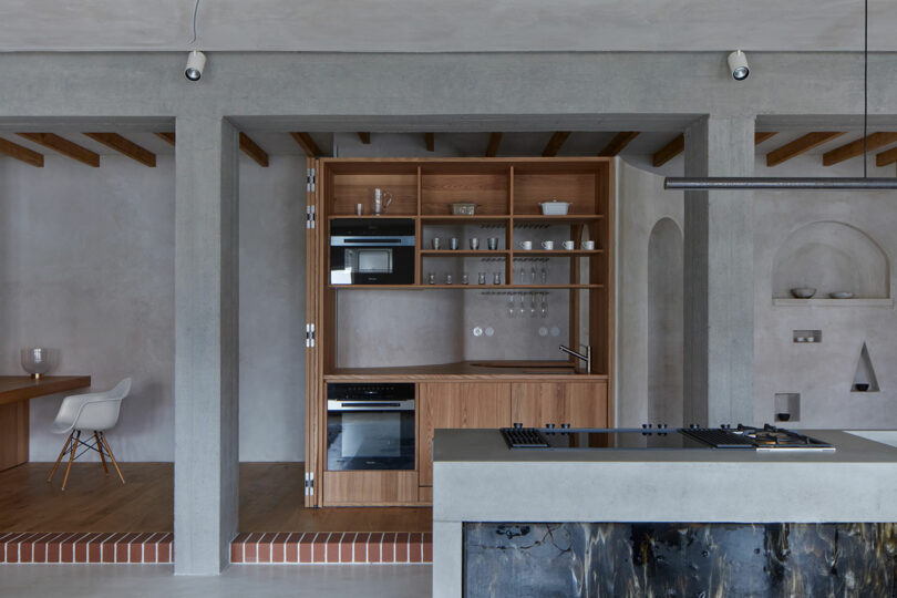 interior partial view of modern kitchen in gray apartment with wood cabinets open