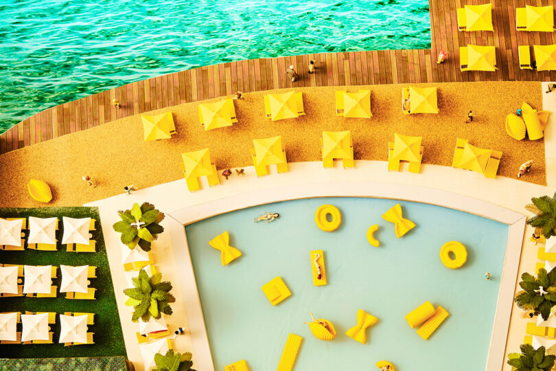 miniature scene of swimming pool with tiny pasta-shaped floats with random people
