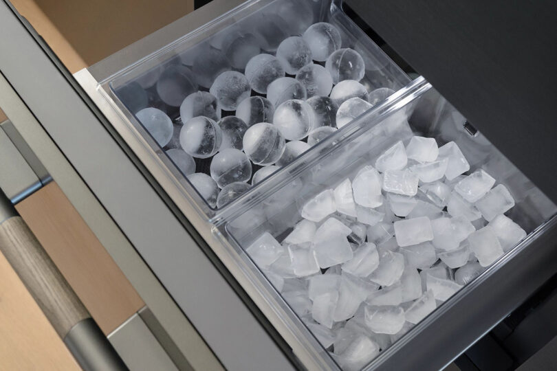 SKS 48" refrigerator freezer ice drawers open filled with two different shapes of ice, round on the left and cubes on the right.