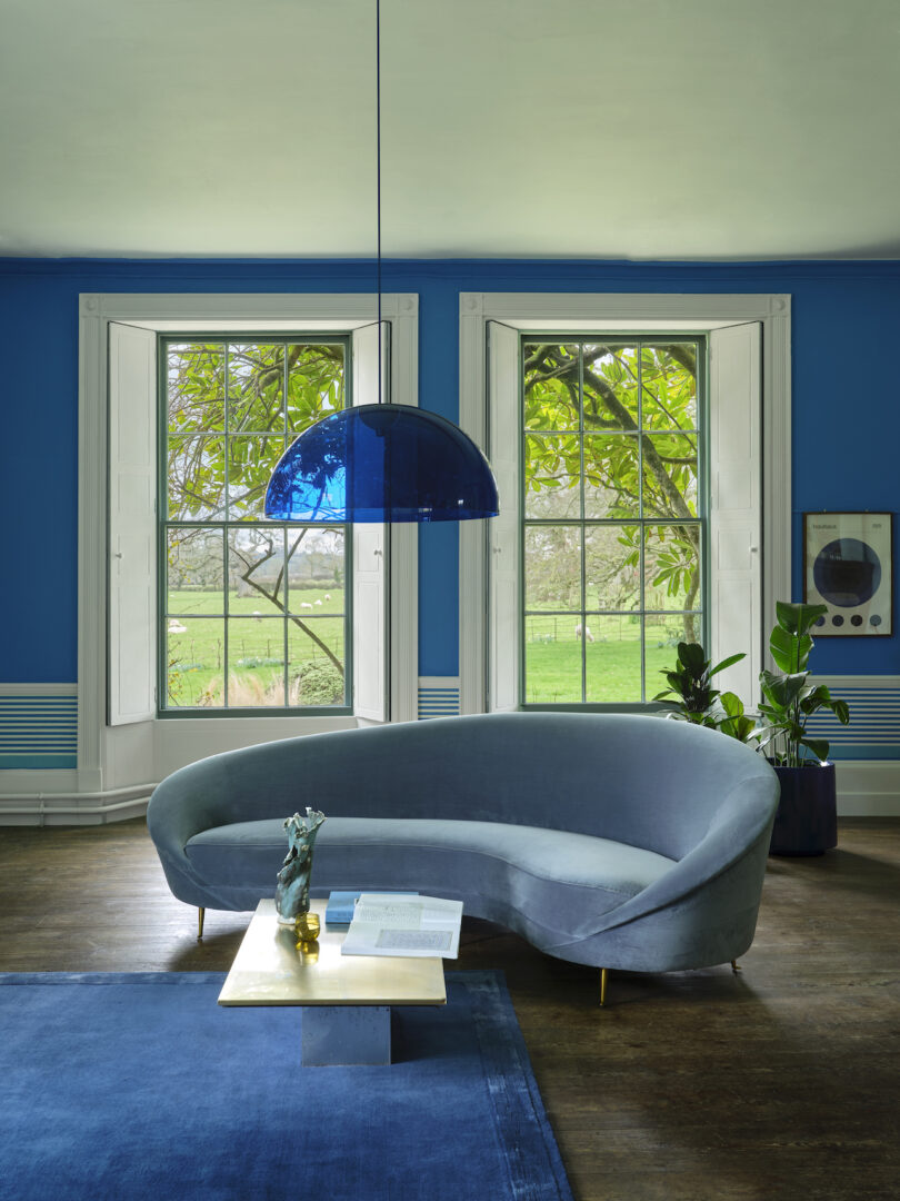 blue painted room with blue pendant, blue sofa and blue rug