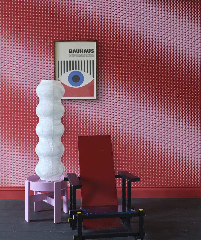 dotted wallpaper with hung art and sculptural lamp