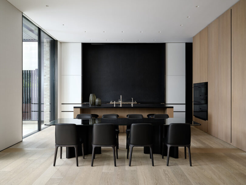 A formal dining room adorned with a polished black stone table, detailed with nickel edging