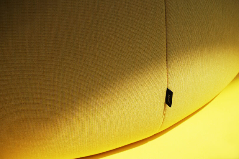 detail of tag on armless yellow lounge chair