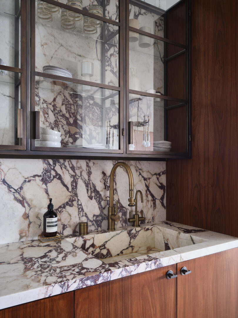 A modern kitchen space highlighting custom antique brass cabinets by DeWinter