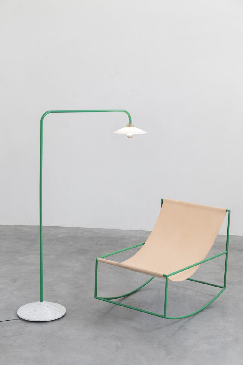 minimalist green lamp next to contemporary sling chair
