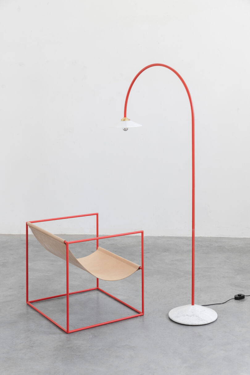 minimalist red lamp next to contemporary sling chair