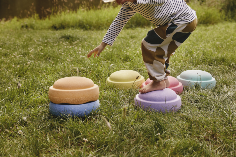 kid stepping on colorful stepping stone toys