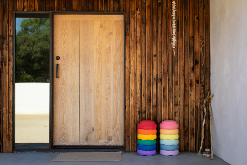 two stacks of colorful stepping stone toys outside next to door