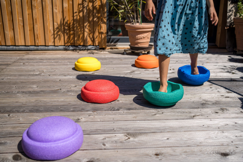 child walking on colorful stepping stone toys