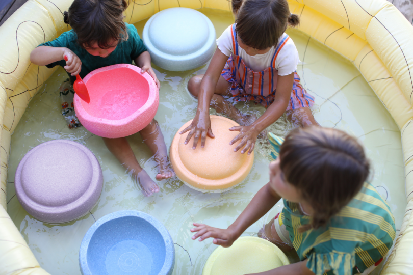 kids playing in pool with colorful stepping stone toys