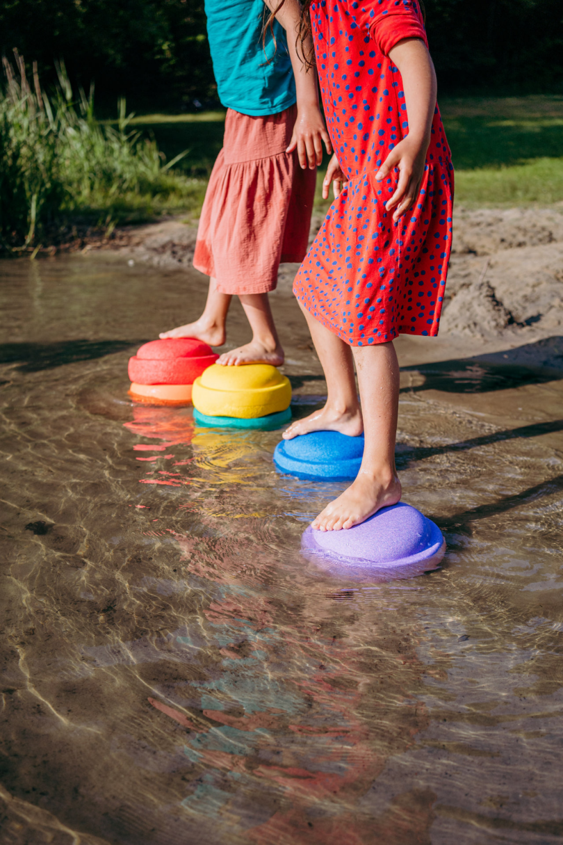 kids standing on colorful stepping stone toys