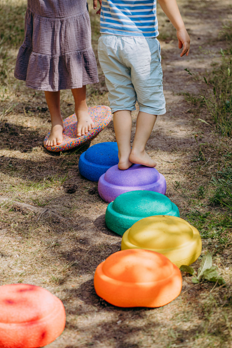 kids standing on colorful stepping stone toys