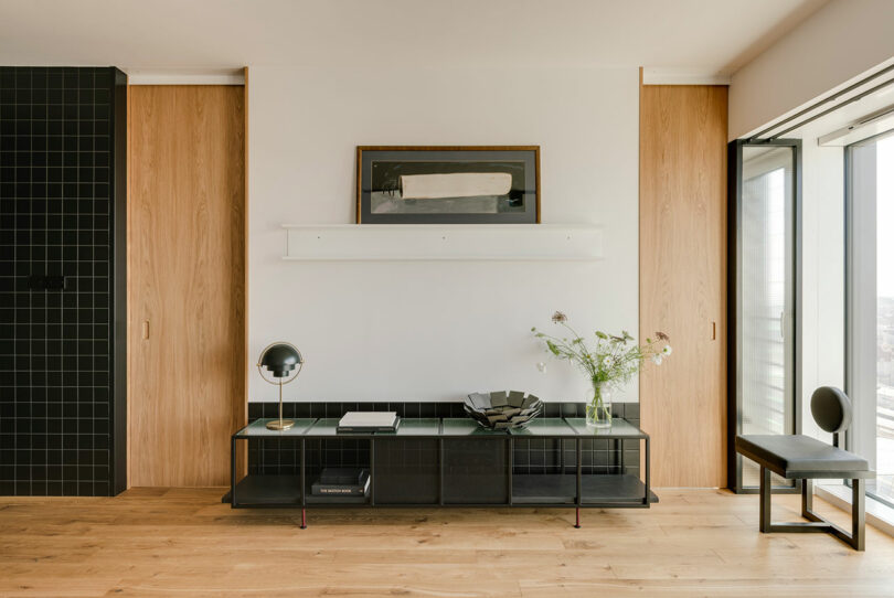 partial view of modern living room interior facing wall between two doors with black console low to ground