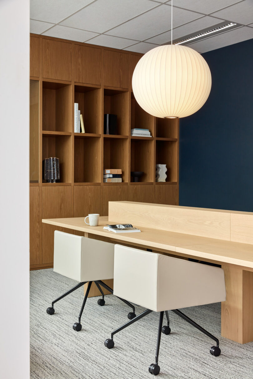 workspace with two modern office chairs, a table, and shelving