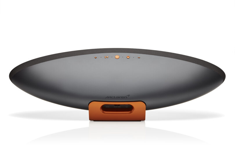 Back view of Bowers & Wilkins Zeppelin McLaren Edition wireless speaker, finished in Galvanic Grey body and Papaya Orange, adorned with McLaren branding, showing control buttons and input ports.