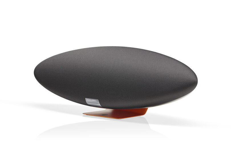 Angled front view of Bowers & Wilkins Zeppelin McLaren Edition wireless speaker, finished in Galvanic Grey body and Papaya Orange, adorned with McLaren branding.
