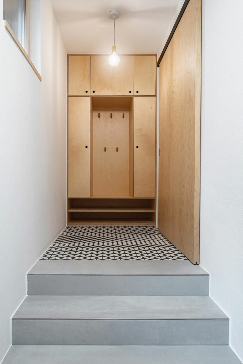 modern entry way with wooden cabinets and tile floor