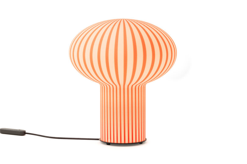 mushroom-shaped orange and white striped table lamp on a white background