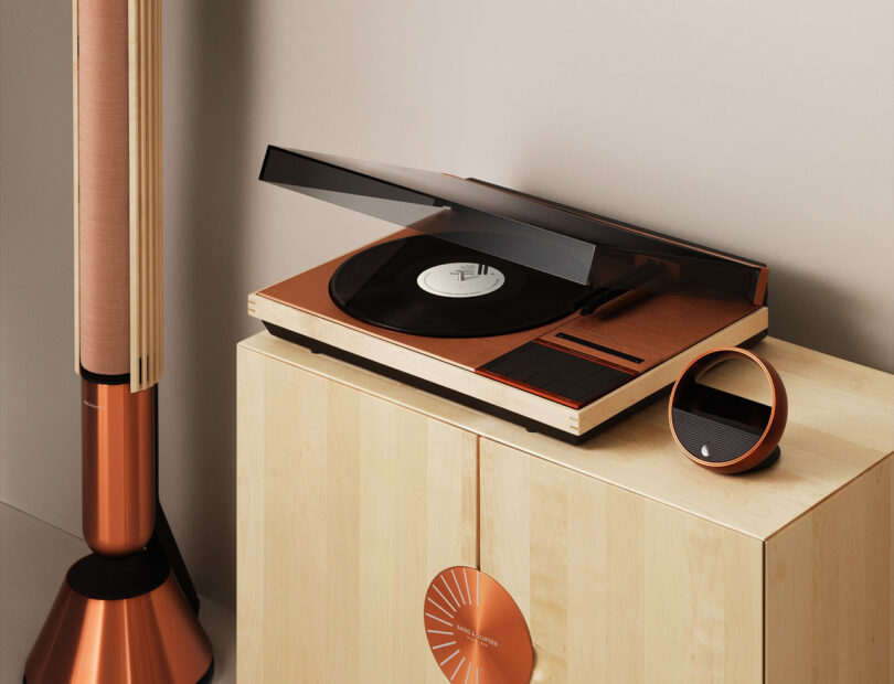rich bronze embellished turntable and floor speakers with matching light wood cabinetry