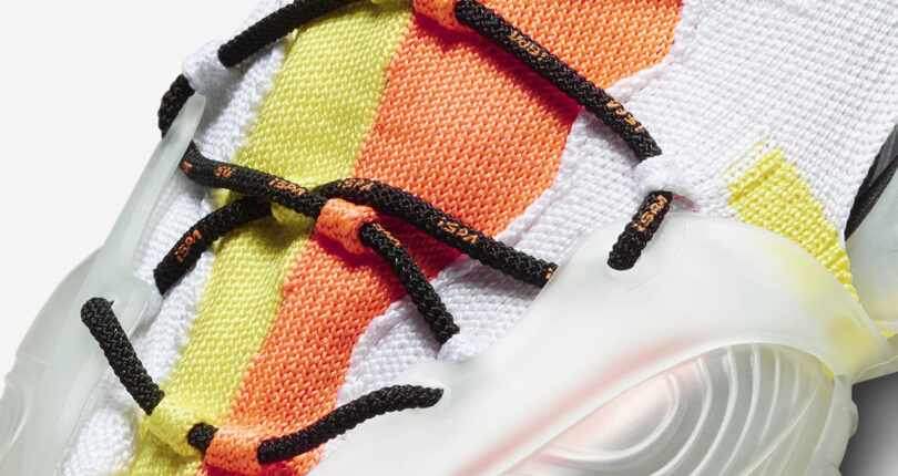 Detail of cord style lacing system tied across orange, yellow and white Nike sneakers