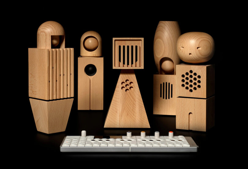 5 wooden doll speakers in front of a small synthesizer keyboard