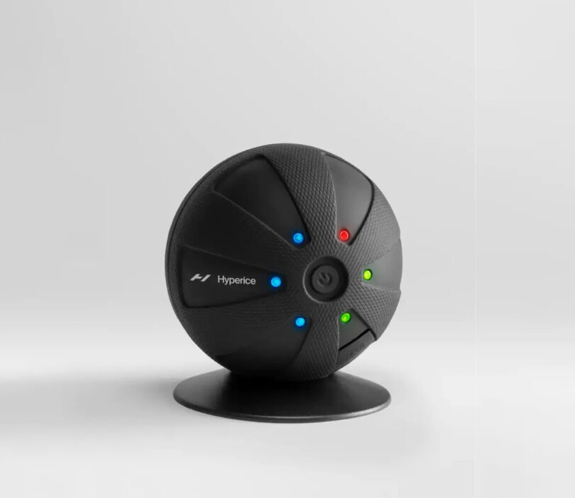Black round vibrating massage ball with six multi-colored LED lights.