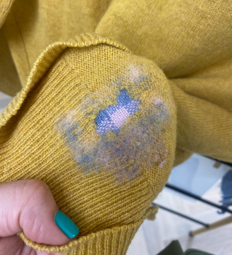 A patched and felted cuff of a yellow jumper.