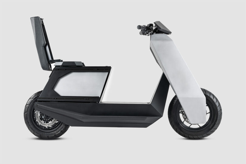 Infinite Machine P1 electric scooter with its seat lid lifted and side panel removed to showcase cargo storage and modular add-on storage system.