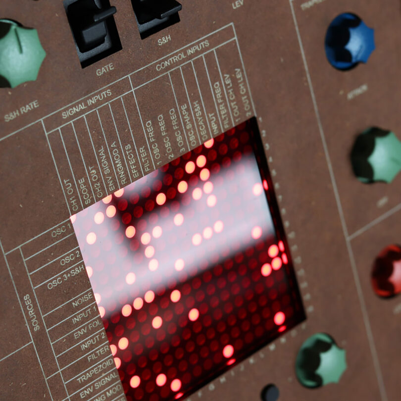 Close up of LED matrix display inset into wood cabinet synthesizer showing relationship between signal, control inputs and sources.