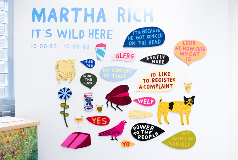 gallery wall filled with small, colorful pieces of painted wood objects and speech balloons reading Martha Rich It's Wild in Here