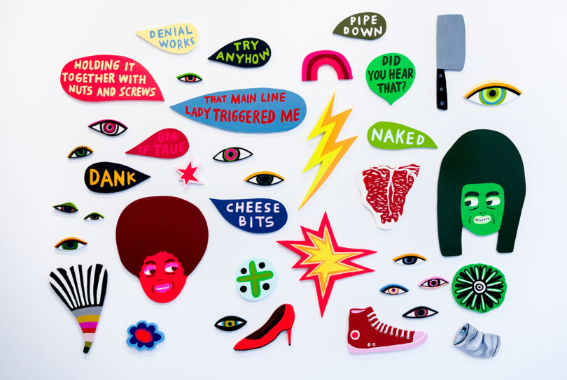 gallery wall filled with small, colorful pieces of painted wood objects and speech balloons