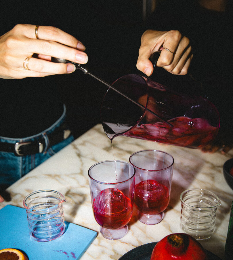 high contrast flash image of someone preparing two cocktails