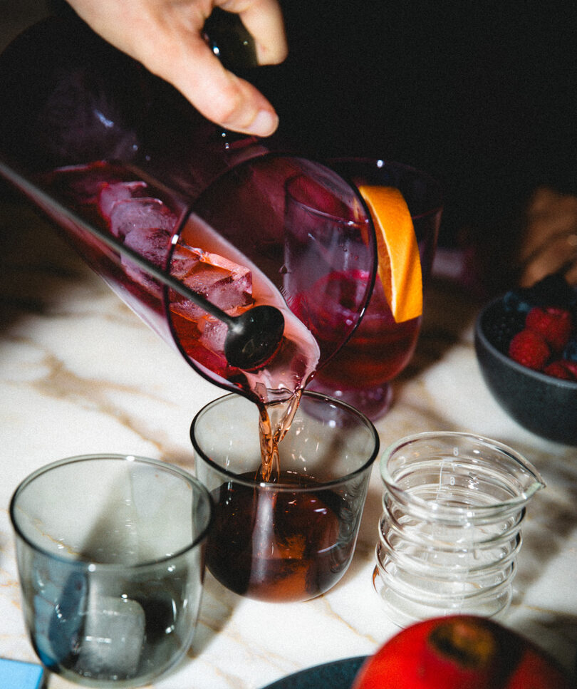 high contrast flash image of someone pouring two cocktails