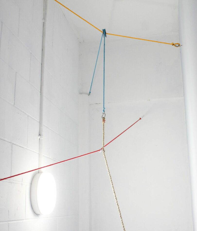 Rope is different colours is attached across a white-painted space