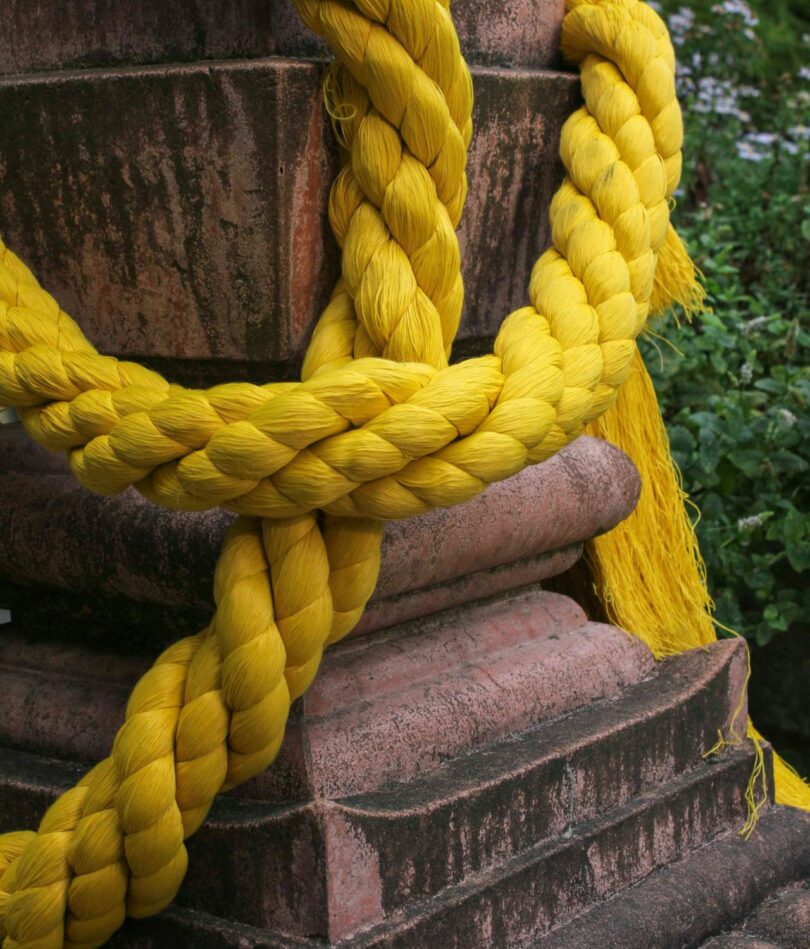 Heavy yellow cord is draped across a column