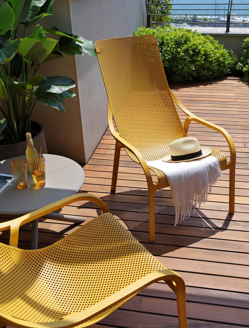 two yellow hard plastic lounge chairs on an outdoor deck