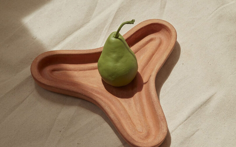 A terracotta fruit platter with a ribbed base, designed to allow fruit to breathe.