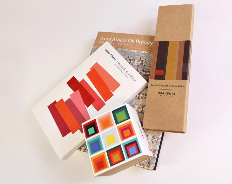 Cardboard packaging for Project Watches x Albers Foundation timepieces staged alongside Josef Alber's book Interaction of Color, a boxed set of Josef's Homage to the Square paintings, and Anni Albers' book, On Weaving.