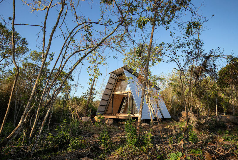 vista exterior angular da moderna cabana pré-fabricada na floresta circundante