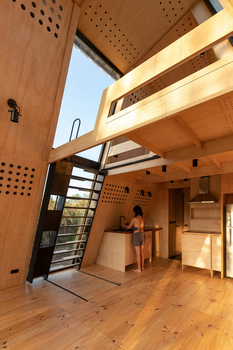 vista interior angular da cabine moderna com paredes de madeira inclinadas e decoração minimalista