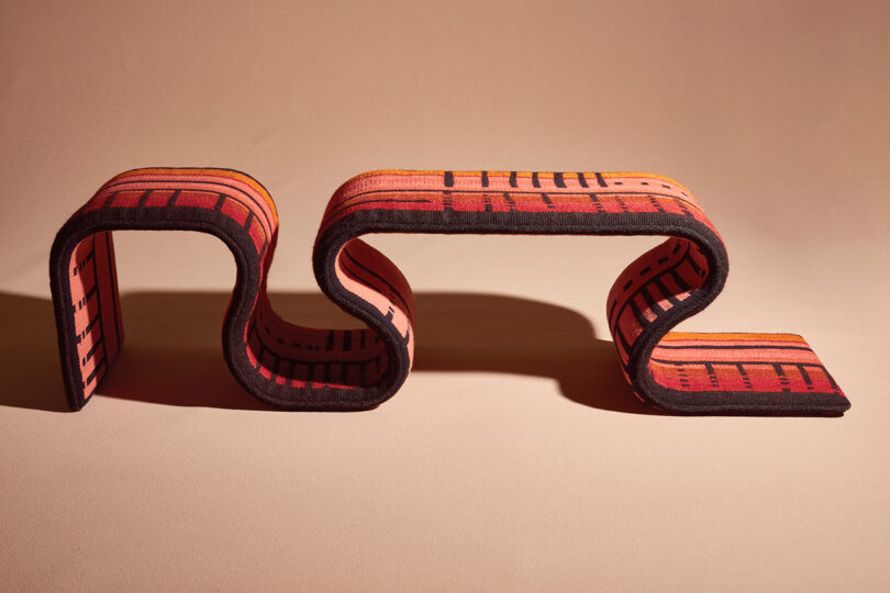 red woven bench with an undulating shape