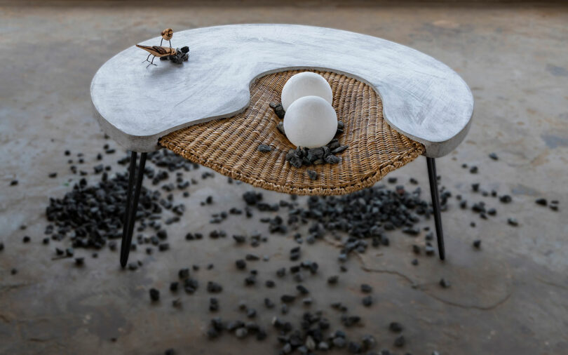 Aerial angled view of round concrete and rattan coffee table.