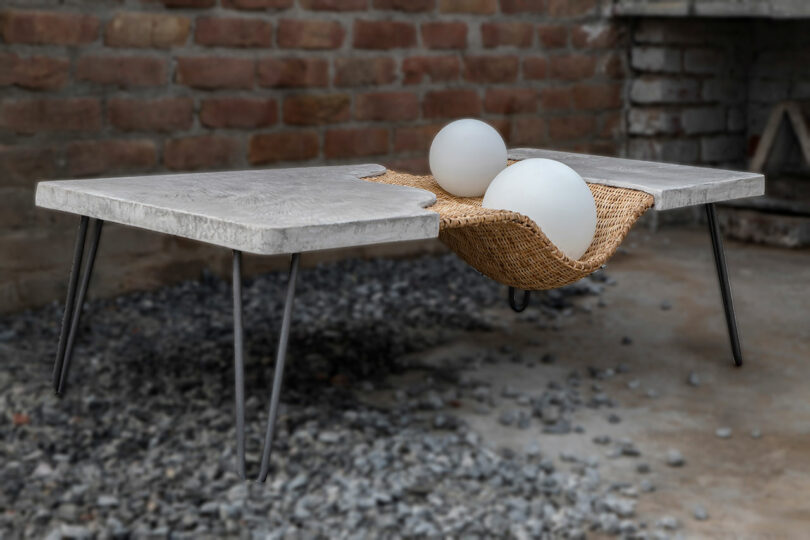 Angled view of concrete and rattan rectangular coffee table.